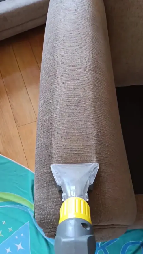 Hot-water extraction wand on a sofa