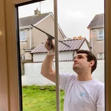 Yevhen cleaning an outside window