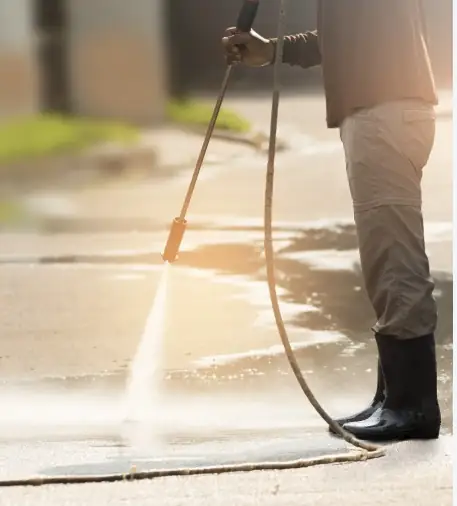 Pressure washing a driveway in Donegal: high-pressure lance stripping dirt and moss off concrete