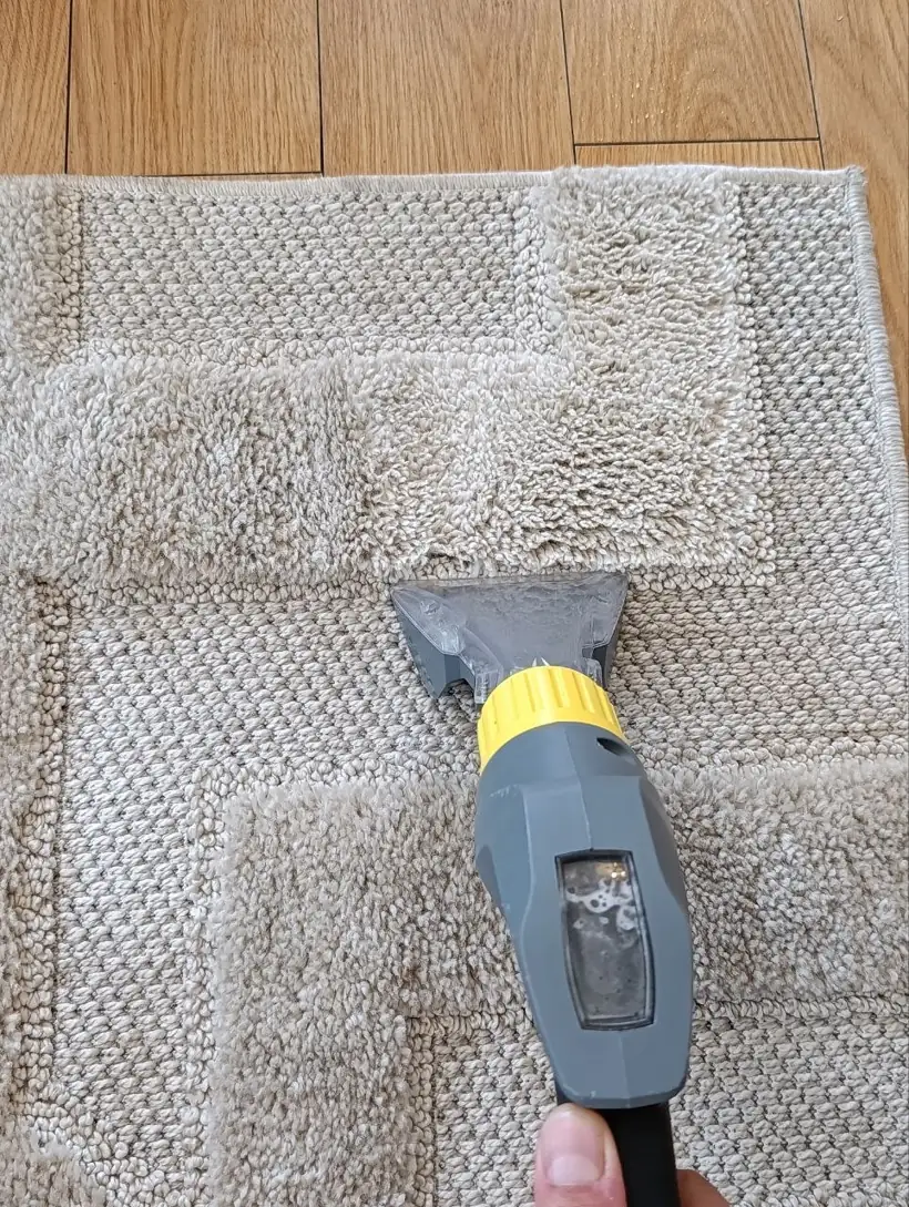 Rug cleaning in Letterkenny: extraction head lifting dirt out of a cream rug, dirty water visible in the tank