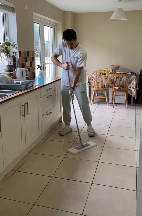 Yevhen washing a kitchen floor during a deep clean