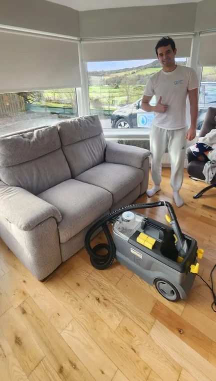 Yevhen with his extraction machine beside a sofa